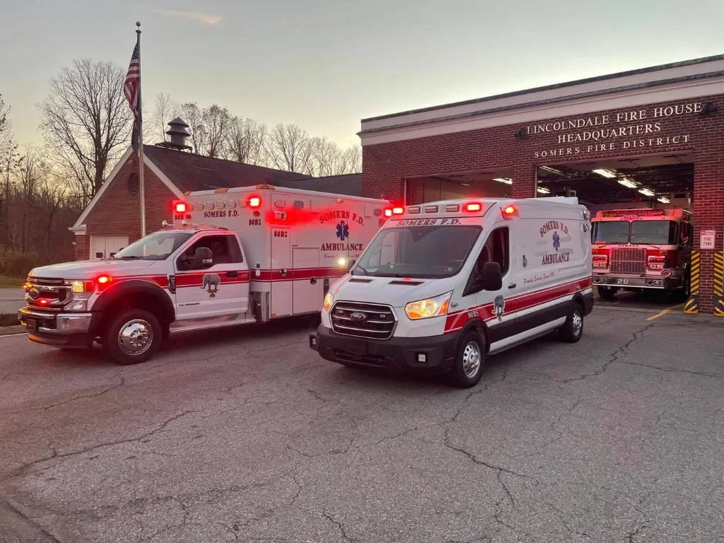 The department's new Horton and Medix ambulances with their emergency lights on at the station.