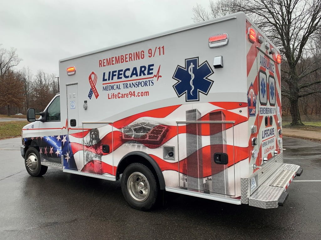 The LifeCare Medical Transports ambulance has graphics on the side of the box that depict September 11, 2001.