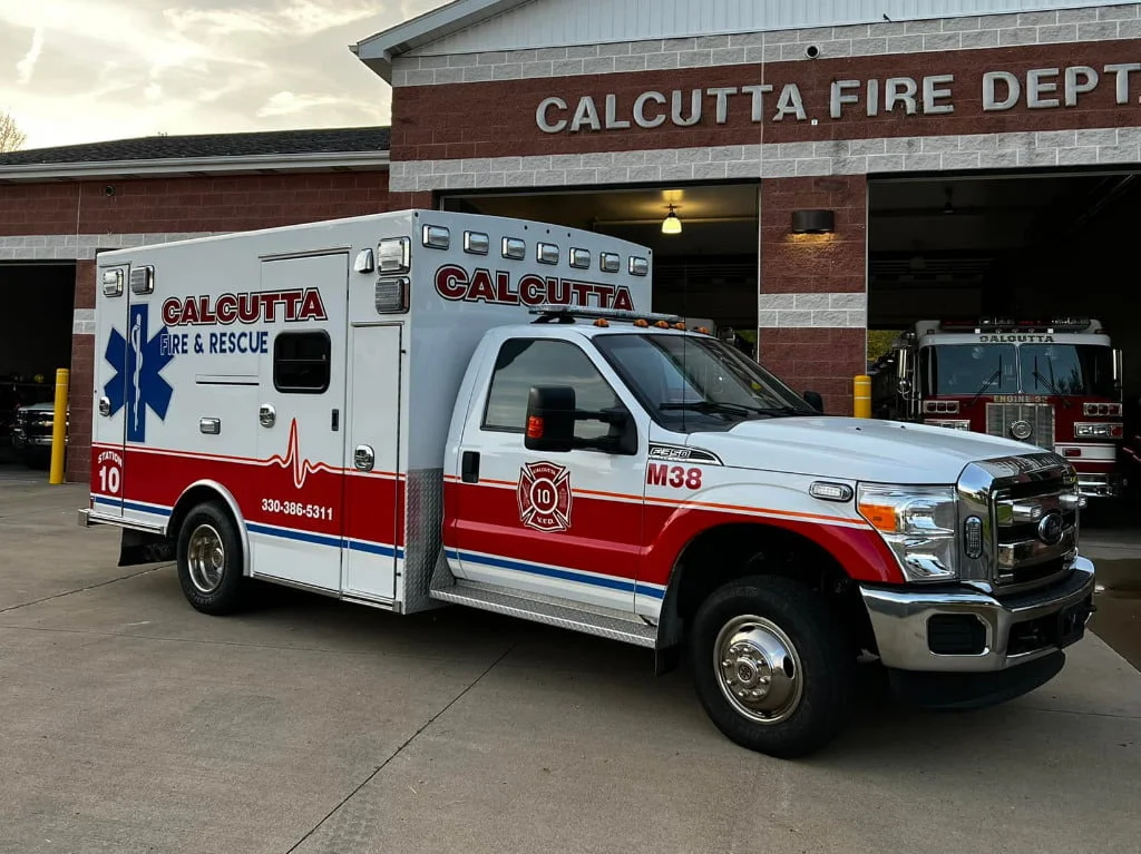 The Calcutta Fire Department's new ambulance sits in front a garage bays.