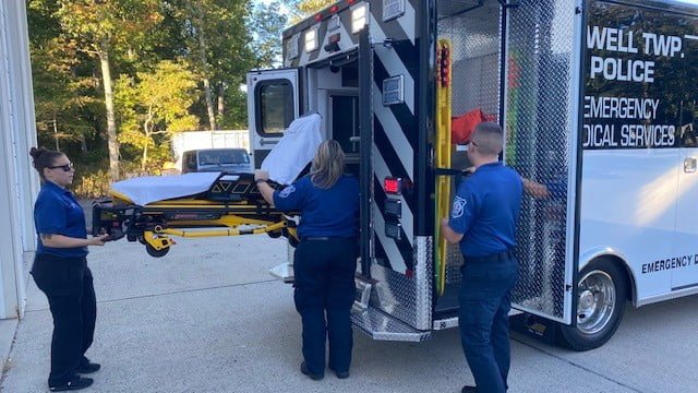 Howell Township medical staffers load a Stryker PowerCOT into the rear of their new AEV ambulance.