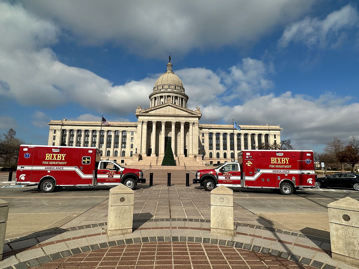 Two ambulances parked outside a large granite building with a rotunda.