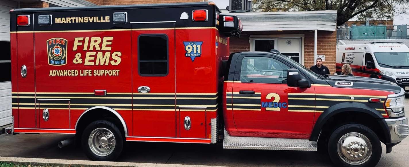 A red ambulance shows from the passenger side.