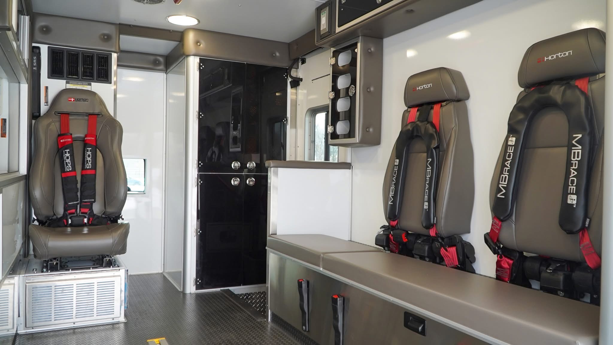 Acrylic-faced cabinets are above the two-seat squad bench, while four glove box holders run down the forward side of the bench.